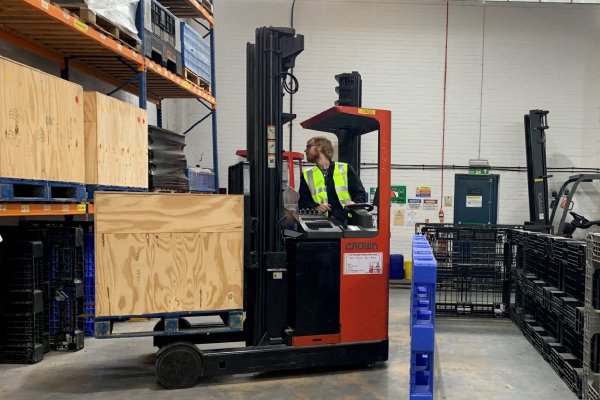 a reach forklift carrying cargo through a training course